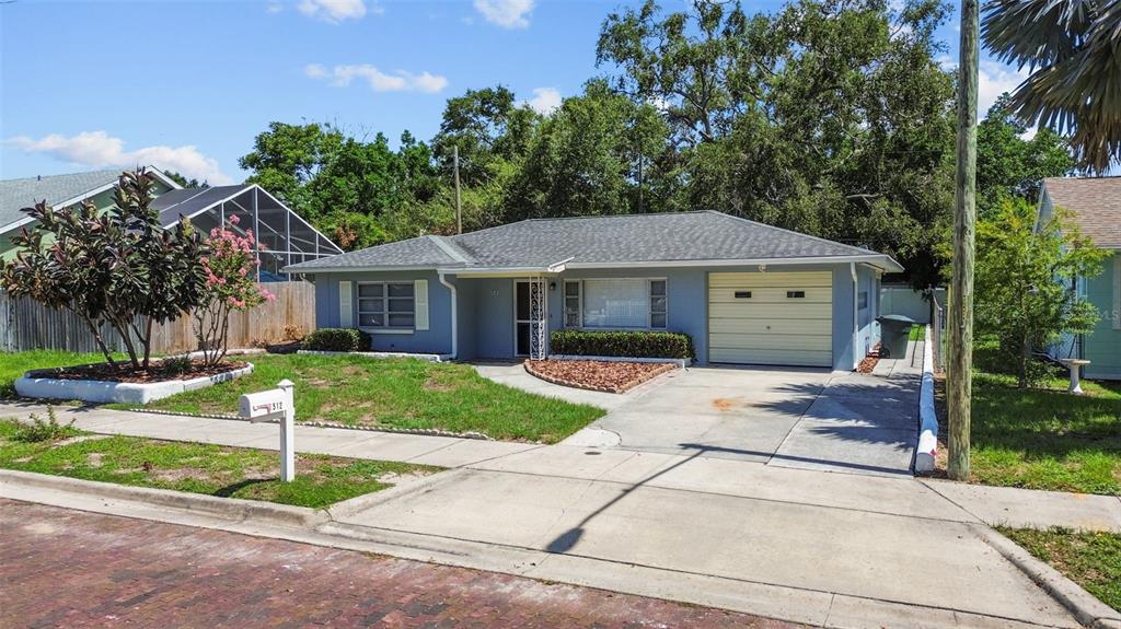512 Richmond Street Dunedin, FL 34698 - Photo 27 of 37 a front view of a house with a yard and garage