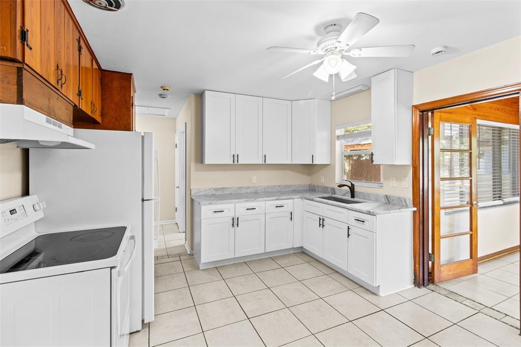 512 Richmond Street Dunedin, FL 34698 - Photo 7 of 37 a kitchen with a stove a sink and a refrigerator
