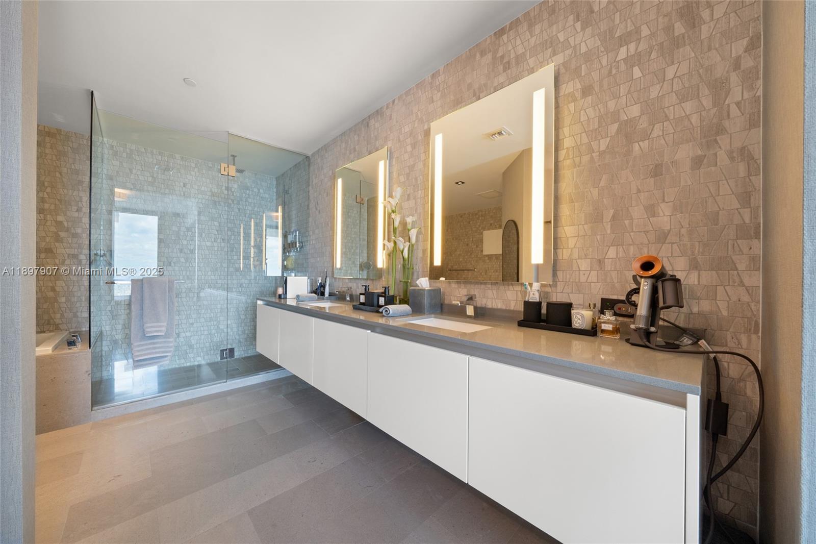 88 Southwest 7th Street, Unit 3910 Miami, FL 33130 - Photo 20 of 38 a large bathroom with a double vanity sink and mirror with shower