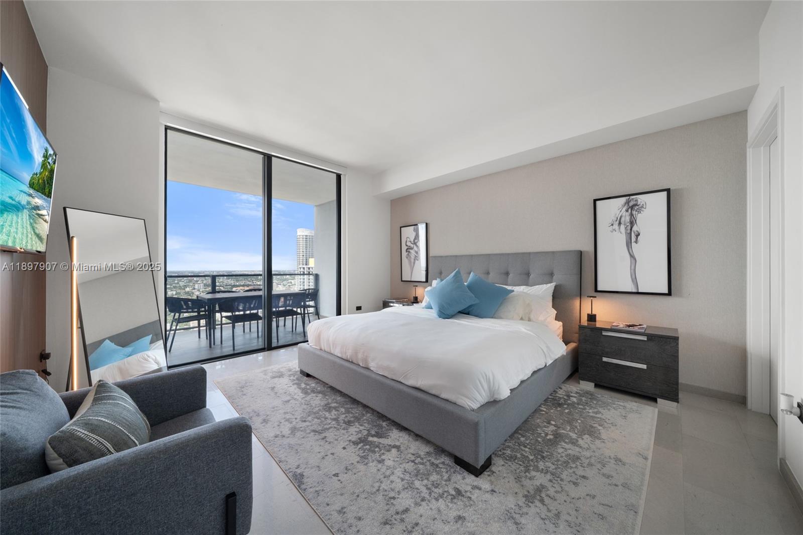 88 Southwest 7th Street, Unit 3910 Miami, FL 33130 - Photo 23 of 38 a spacious bedroom with a bed a couch and a view of kitchen