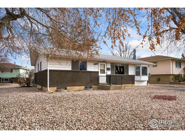 a view of a house with a large tree and a yard