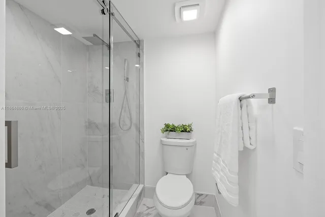 a white toilet sitting next to a bathroom sink