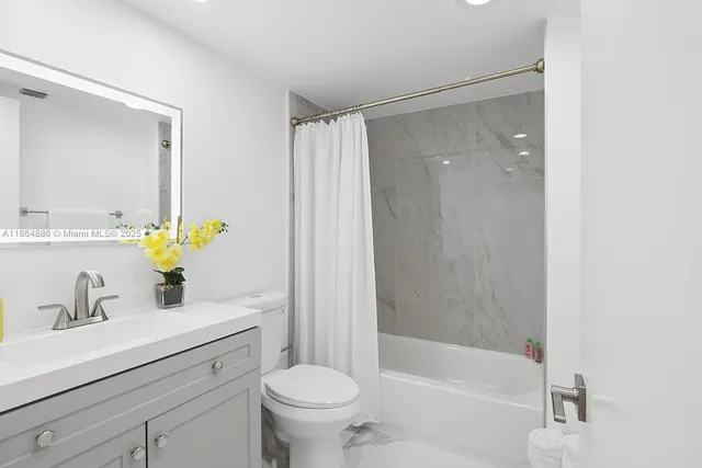 a bathroom with a sink mirror toilet and bathtub