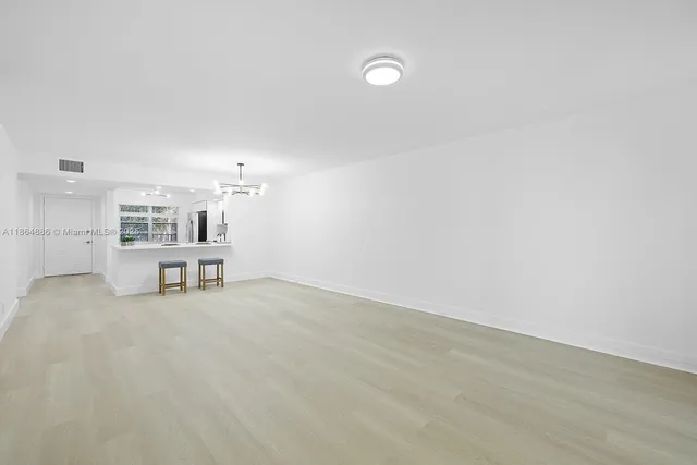 a view of a livingroom with chairs and chandelier fan