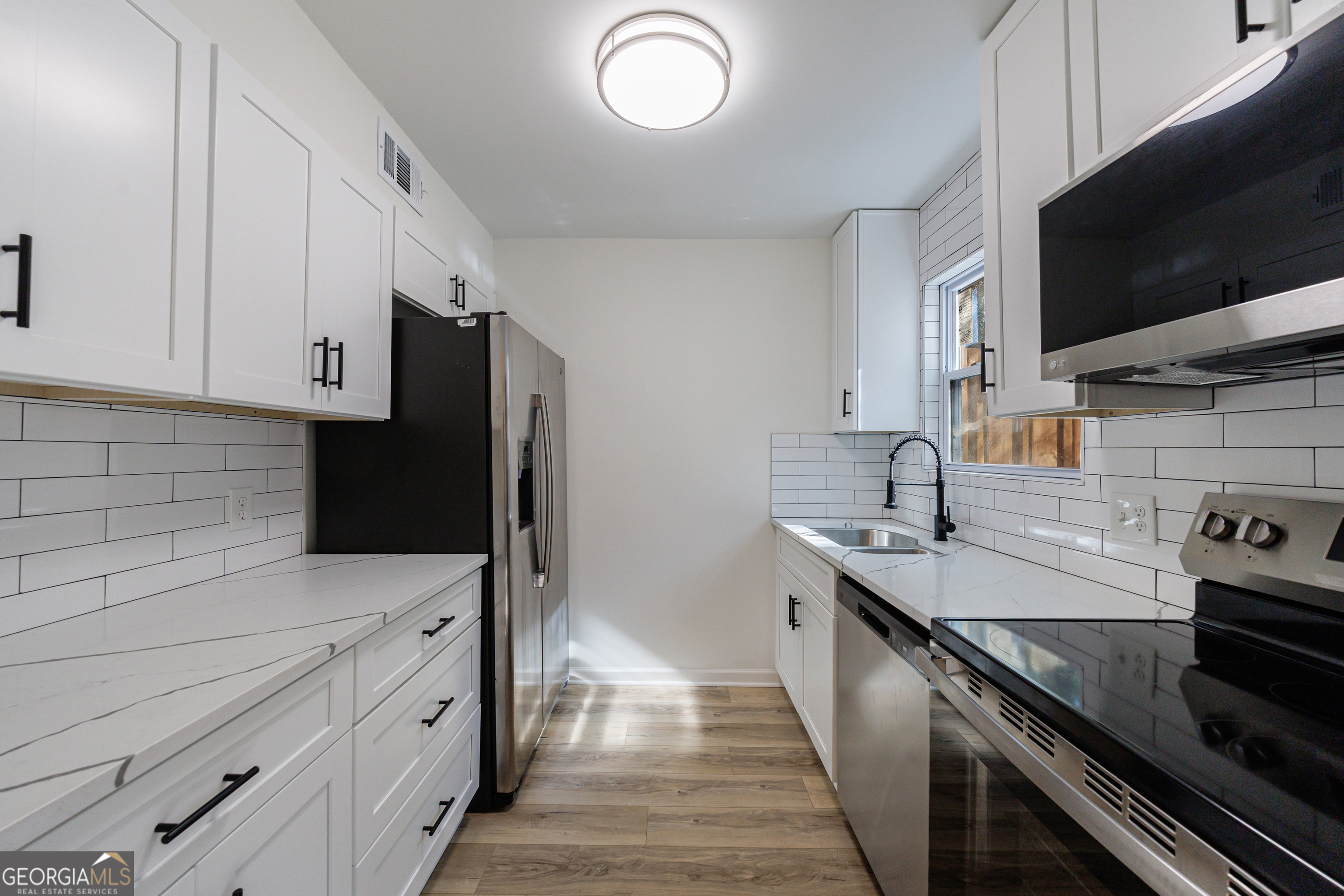 2386 Lawrenceville Highway Decatur, GA 30033 - Photo 14 of 55 a kitchen with granite countertop a sink dishwasher stove and oven with wooden floor