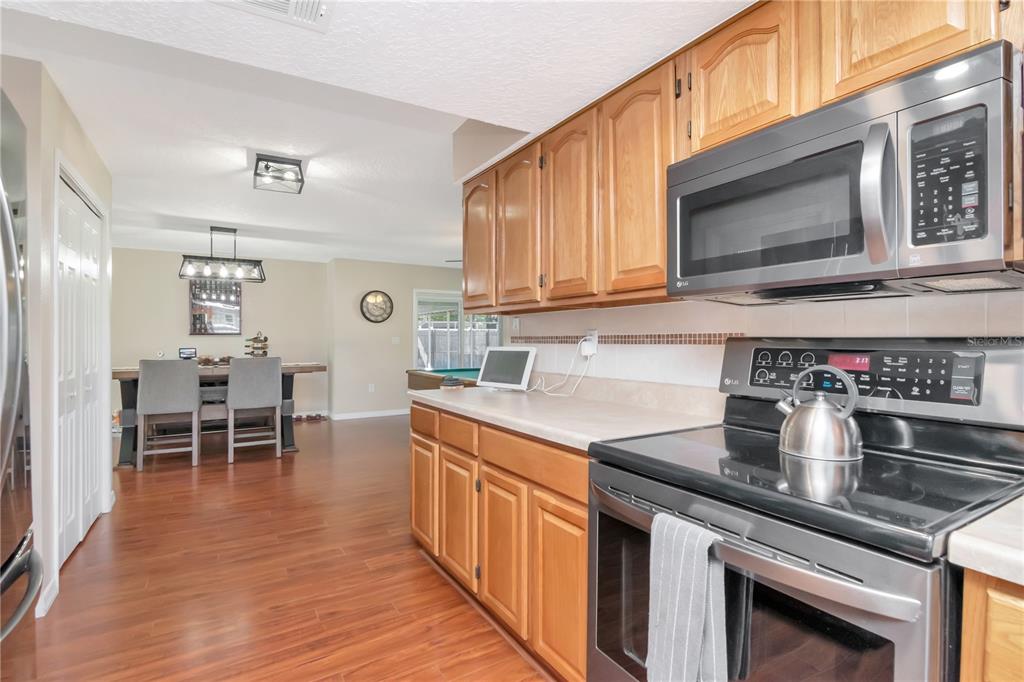 9791 Horizon Drive Spring Hill, FL 34608 - Photo 18 of 38 a kitchen with stainless steel appliances granite countertop a stove a sink and a microwave