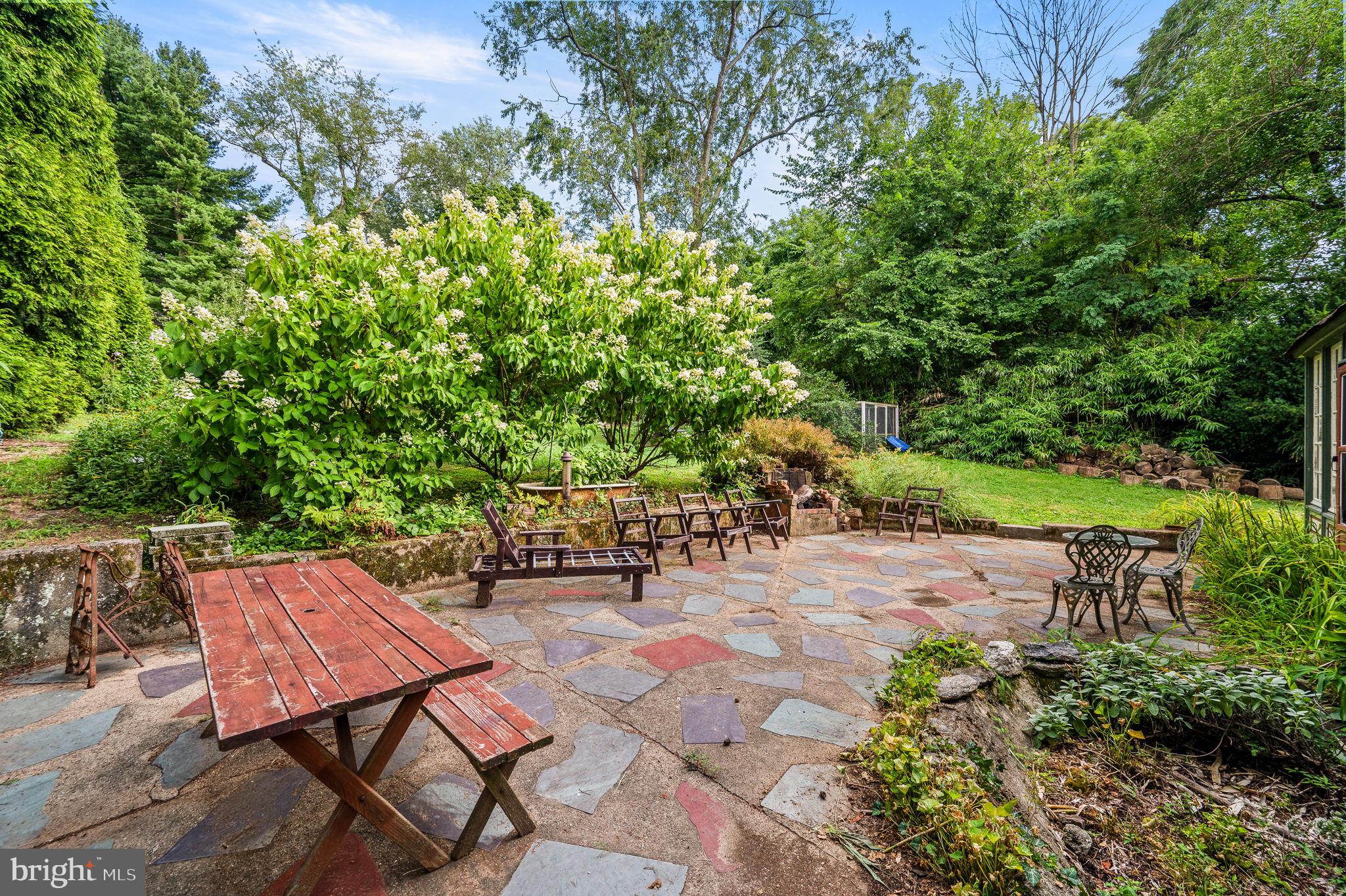 408 East Woodlawn Street Philadelphia, PA 19144 - Photo 25 of 31 a backyard of a house with table and chairs under an umbrella
