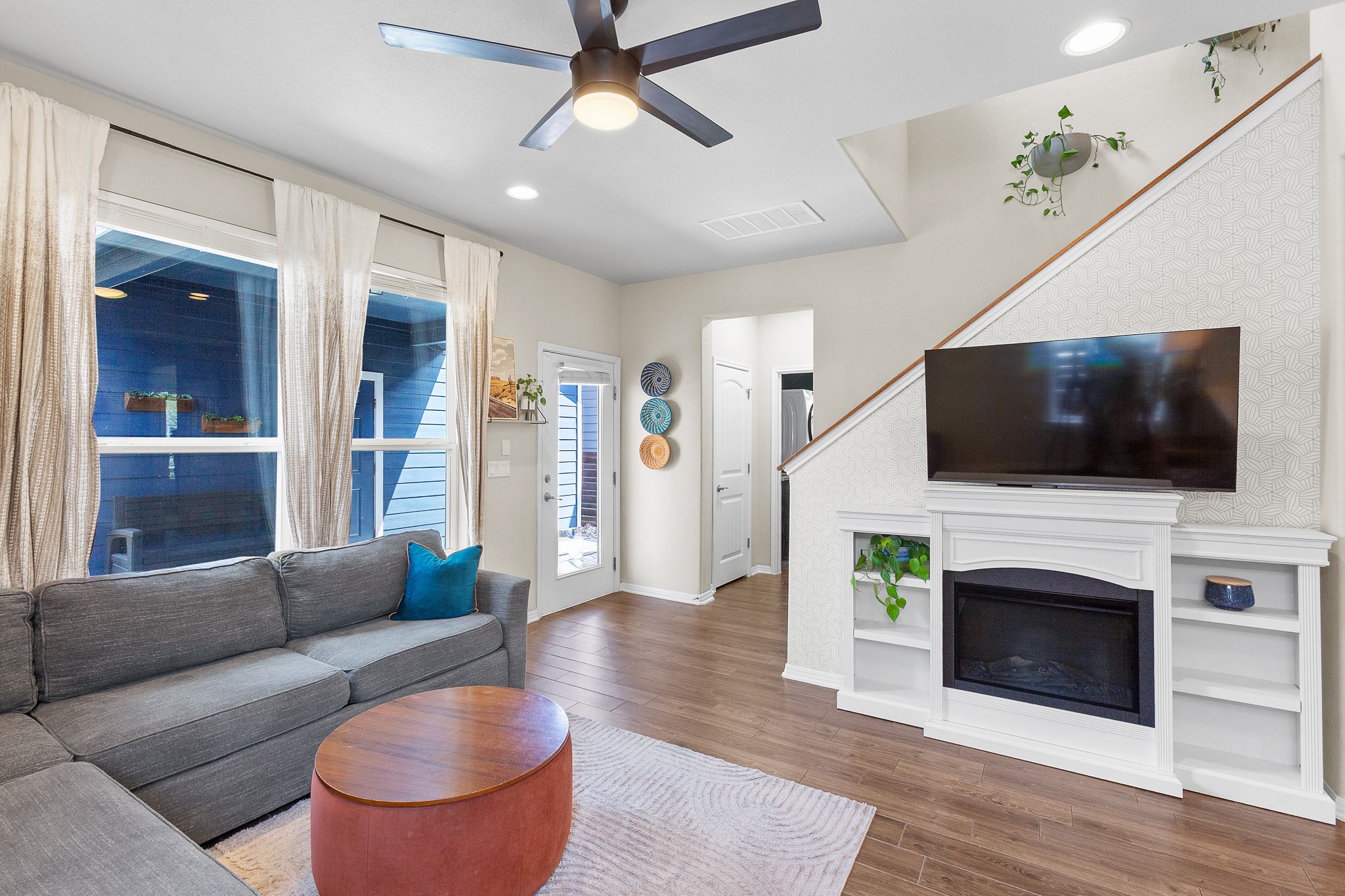 8916 Cattle Baron Path Austin, TX 78747 - Photo 12 of 37 a living room with furniture a flat screen tv and a fireplace