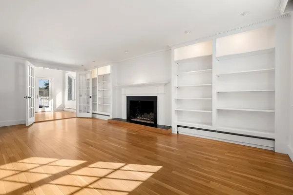 a view of empty room with wooden floor and fireplace