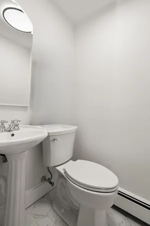 a white toilet sitting next to a bathroom sink
