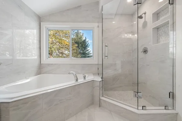 a white bath tub sitting next to a shower