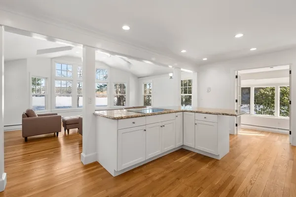 a large kitchen with stainless steel appliances granite countertop a large window and white cabinets