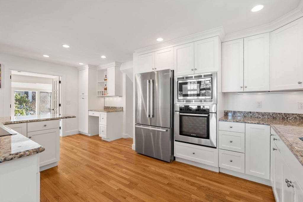31 College Road Wellesley, MA 02482 - Photo 8 of 38 a kitchen with granite countertop a refrigerator oven a sink dishwasher and white cabinets with wooden floor