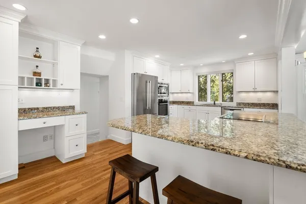 a kitchen with white cabinets and appliances