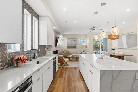 a large kitchen with kitchen island a large counter space a large window and stainless steel appliances