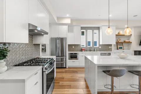 a kitchen with a sink stainless steel appliances and white cabinets