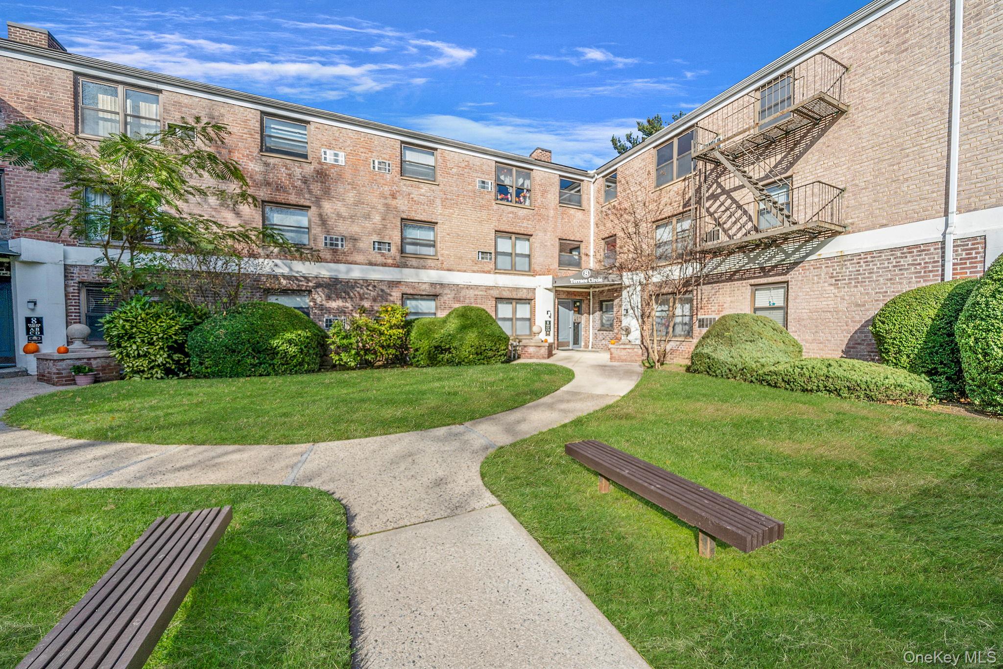 8 Terrace Circle, Unit 1G Great Neck, NY 11021 - Photo 2 of 17 a view of a big building with a big yard and plants