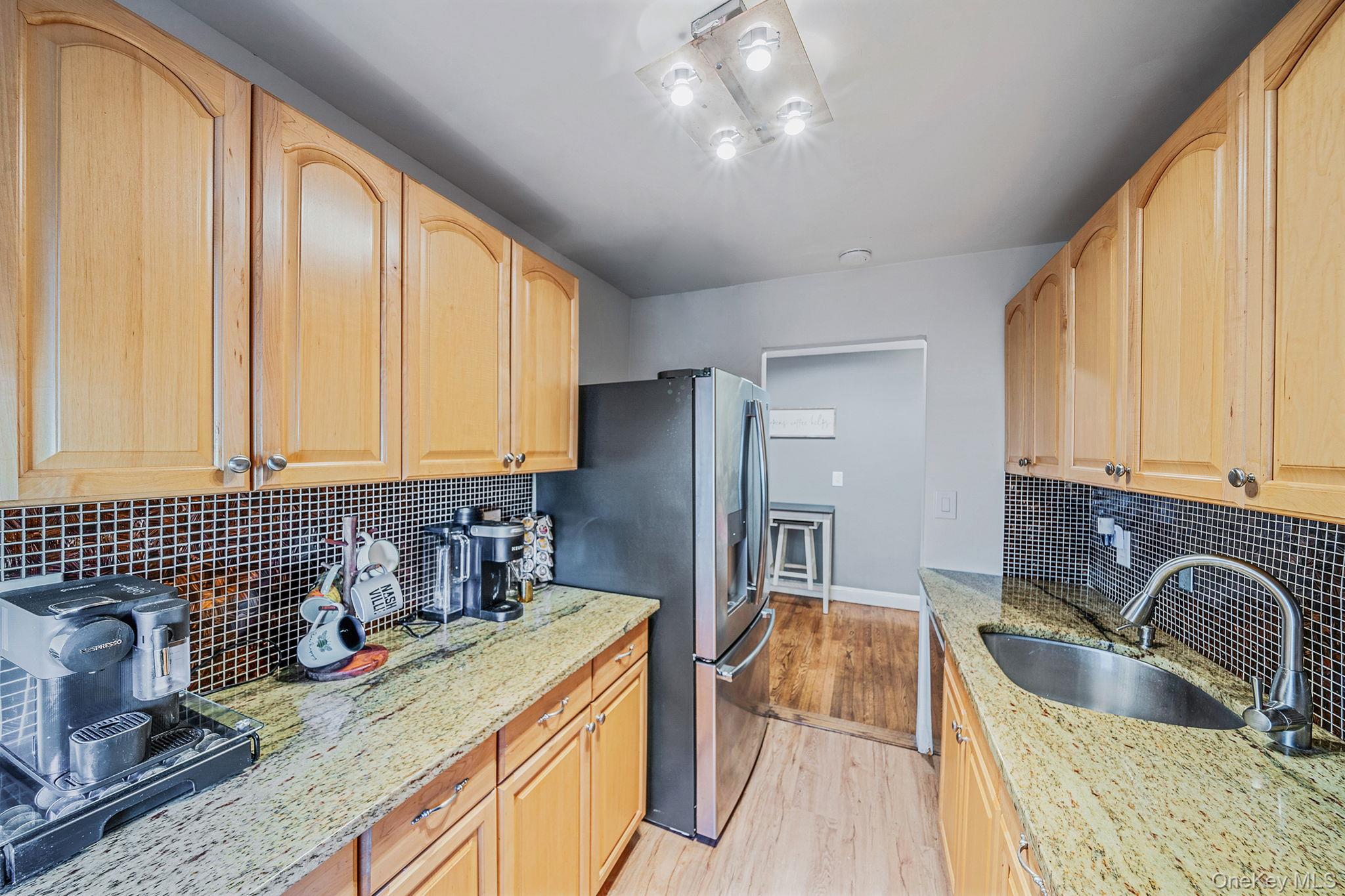 8 Terrace Circle, Unit 1G Great Neck, NY 11021 - Photo 5 of 17 a kitchen with a refrigerator a sink a stove and cabinets