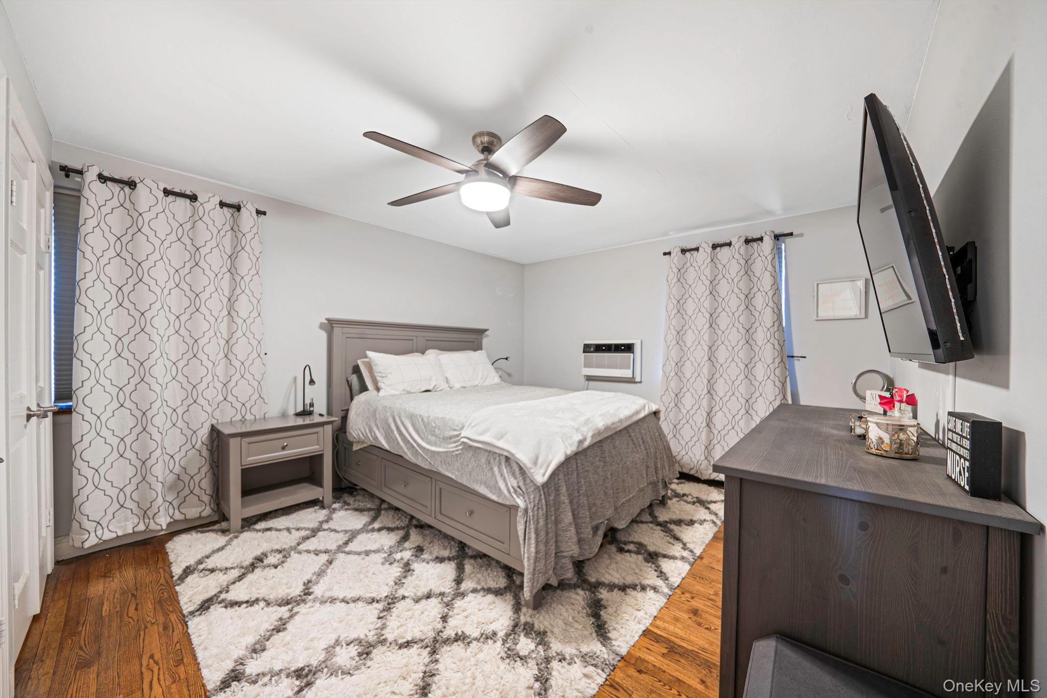 8 Terrace Circle, Unit 1G Great Neck, NY 11021 - Photo 10 of 17 a bedroom with a bed and a flat screen tv