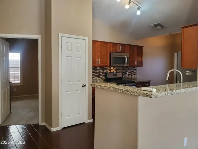 a kitchen with stainless steel appliances granite countertop a stove a microwave and oven