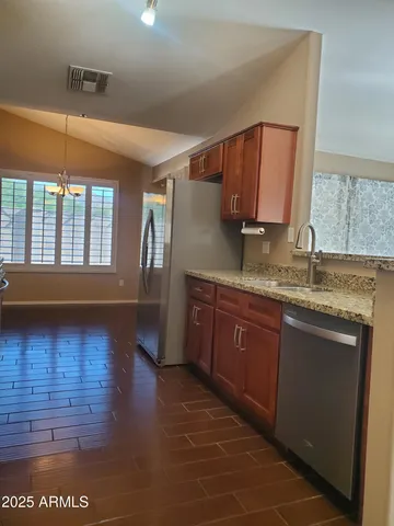 a kitchen with granite countertop stainless steel appliances a sink and cabinets