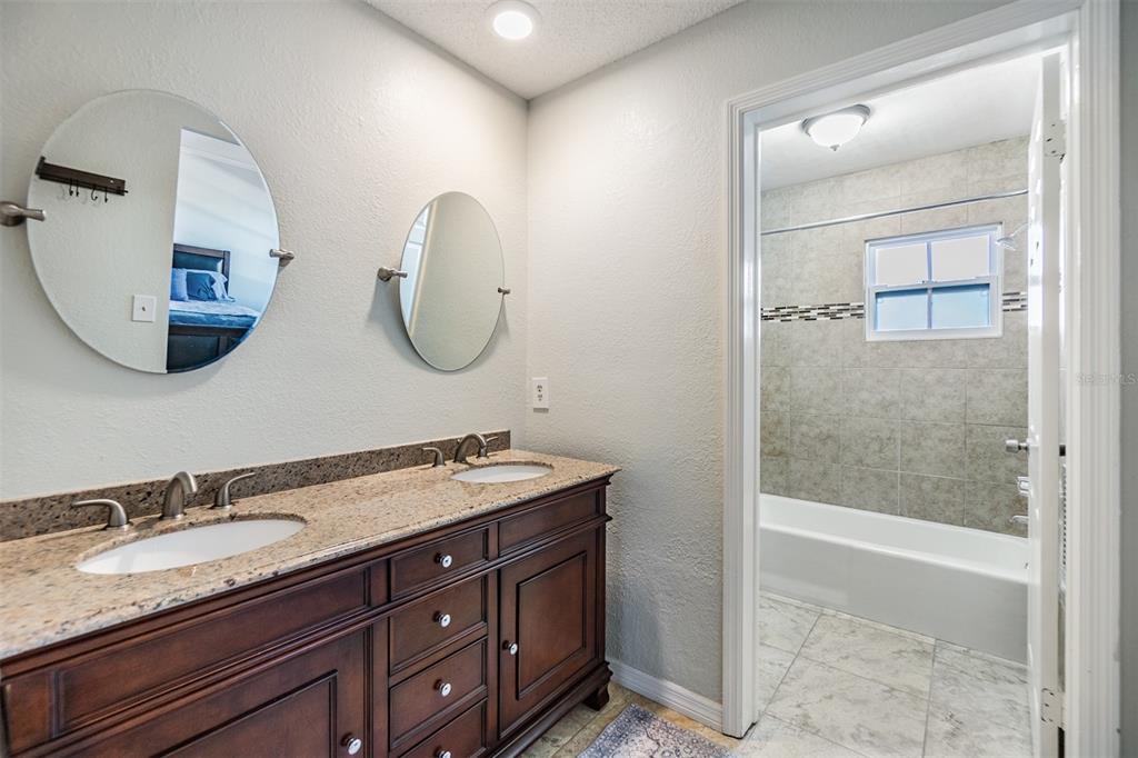 701 Poinsettia Road, Unit 306 Belleair, FL 33756 - Photo 12 of 25 a bathroom with a double vanity sink and a mirror