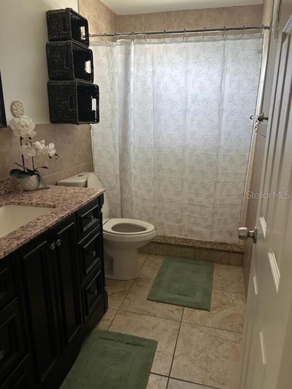 701 Poinsettia Road, Unit 306 Belleair, FL 33756 - Photo 14 of 25 a bathroom with a granite countertop sink toilet and shower