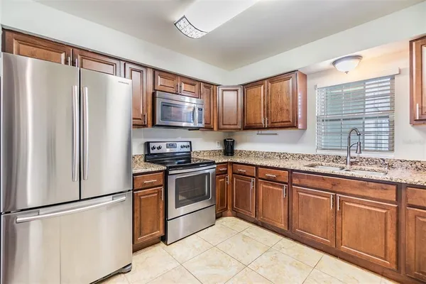 a kitchen with stainless steel appliances granite countertop a refrigerator sink and stove