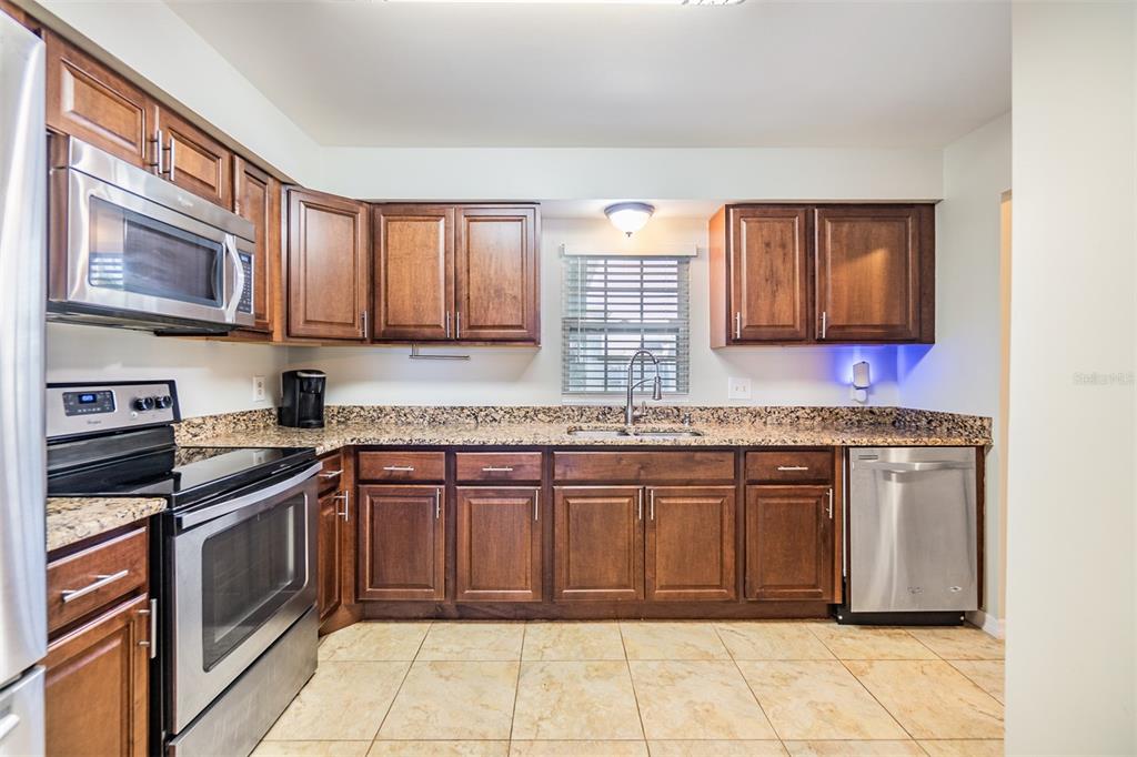 701 Poinsettia Road, Unit 306 Belleair, FL 33756 - Photo 5 of 25 a kitchen with stainless steel appliances granite countertop a stove sink and cabinets