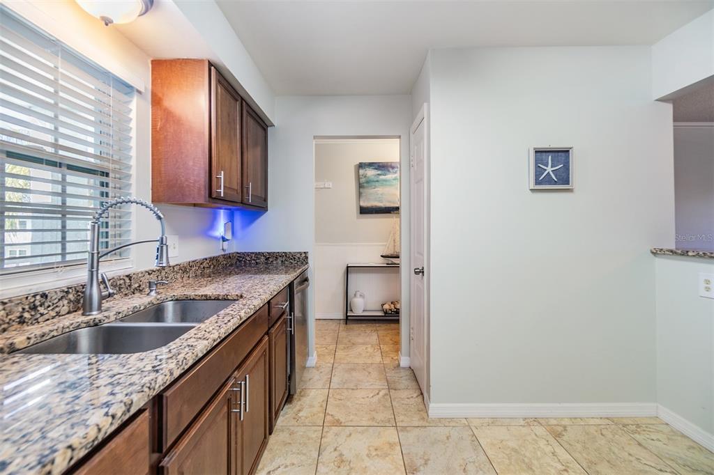 701 Poinsettia Road, Unit 306 Belleair, FL 33756 - Photo 6 of 25 a kitchen with granite countertop a sink and a stove