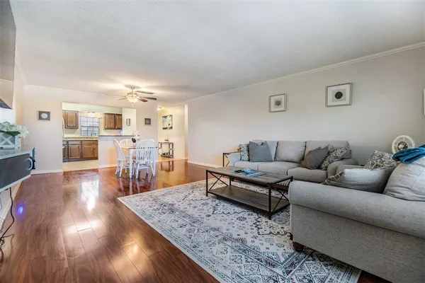a living room with furniture and a wooden floor