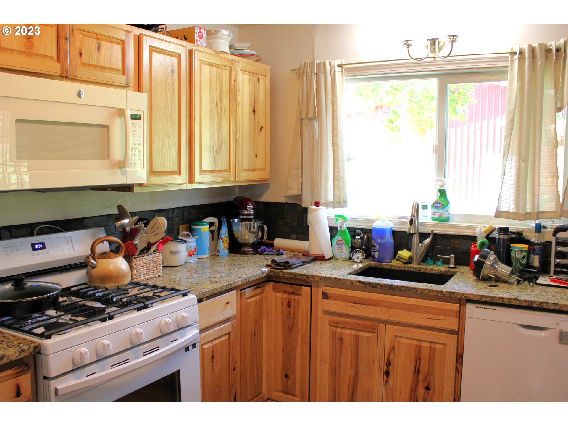3392 Eagle Valley Road Yoncalla, OR 97499 - Photo 11 of 48 a kitchen with sink a window and cabinets