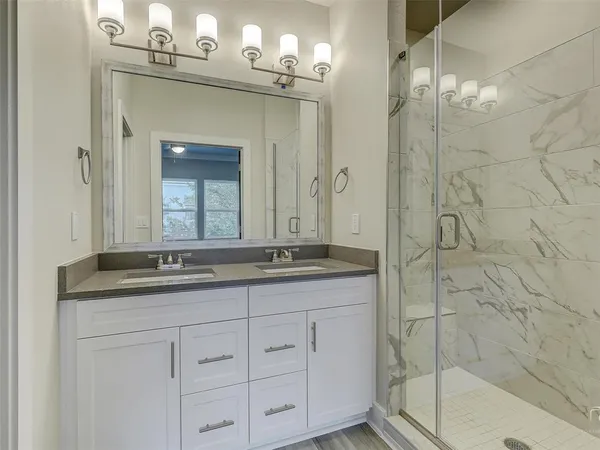 a bathroom with double sink and a mirror