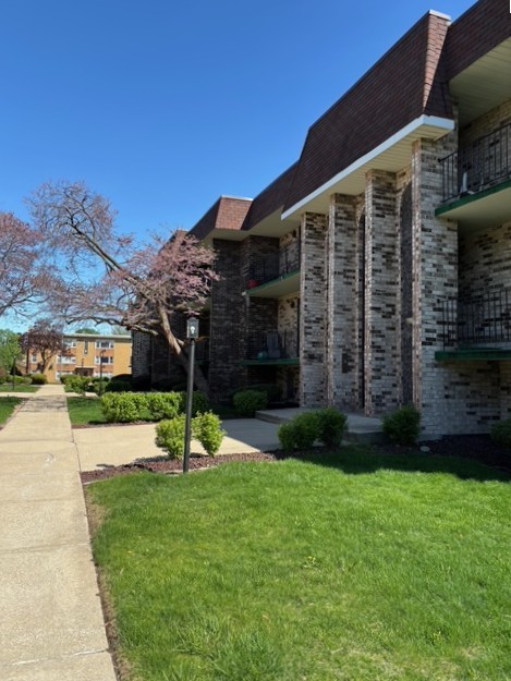 9132 South Pulaski Road, Unit 2E Oak Lawn, IL 60453 - Photo 3 of 22 a view of a house with a yard
