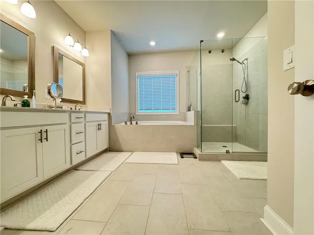 a spacious bathroom with a mirror a shower and a sink