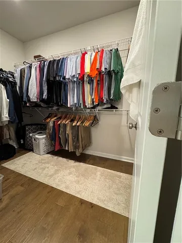 a view of walk in closet with clothes and shoes