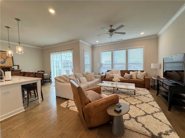 a living room with furniture a flat screen tv and a large window