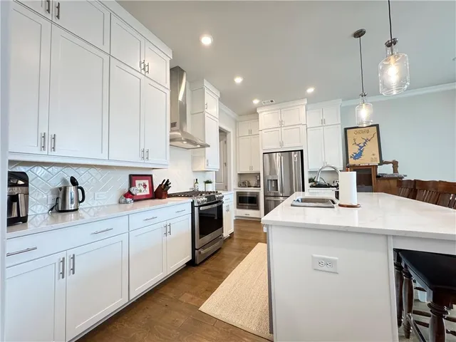 a kitchen with kitchen island granite countertop a sink a stove and cabinets