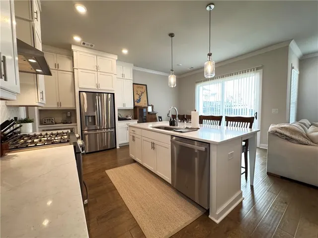 a kitchen with a sink refrigerator and cabinets