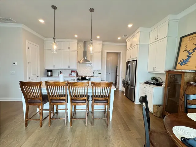 a dining room with furniture a chandelier and wooden floor