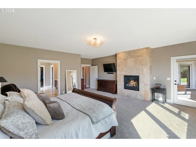 a bedroom with a large bed and a fireplace