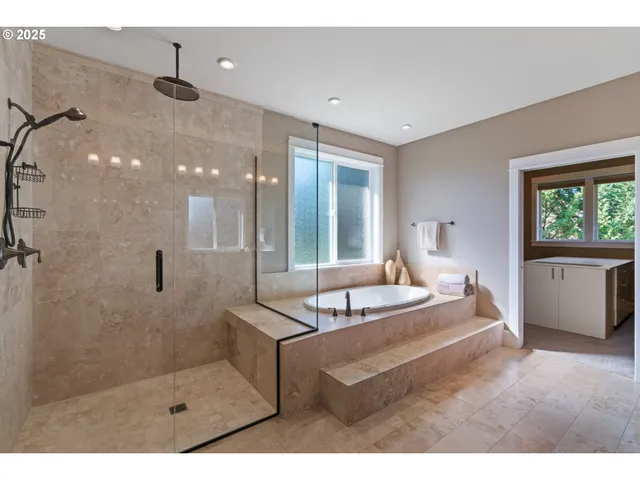 a spacious bathroom with a tub sink shower and mirror