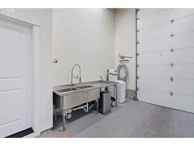 a view of a sink and utility room with racks on the wall