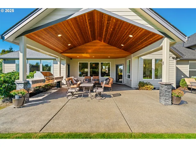 a view of a patio with table and chairs under an umbrella