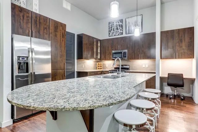 a kitchen with stainless steel appliances granite countertop a sink refrigerator and microwave