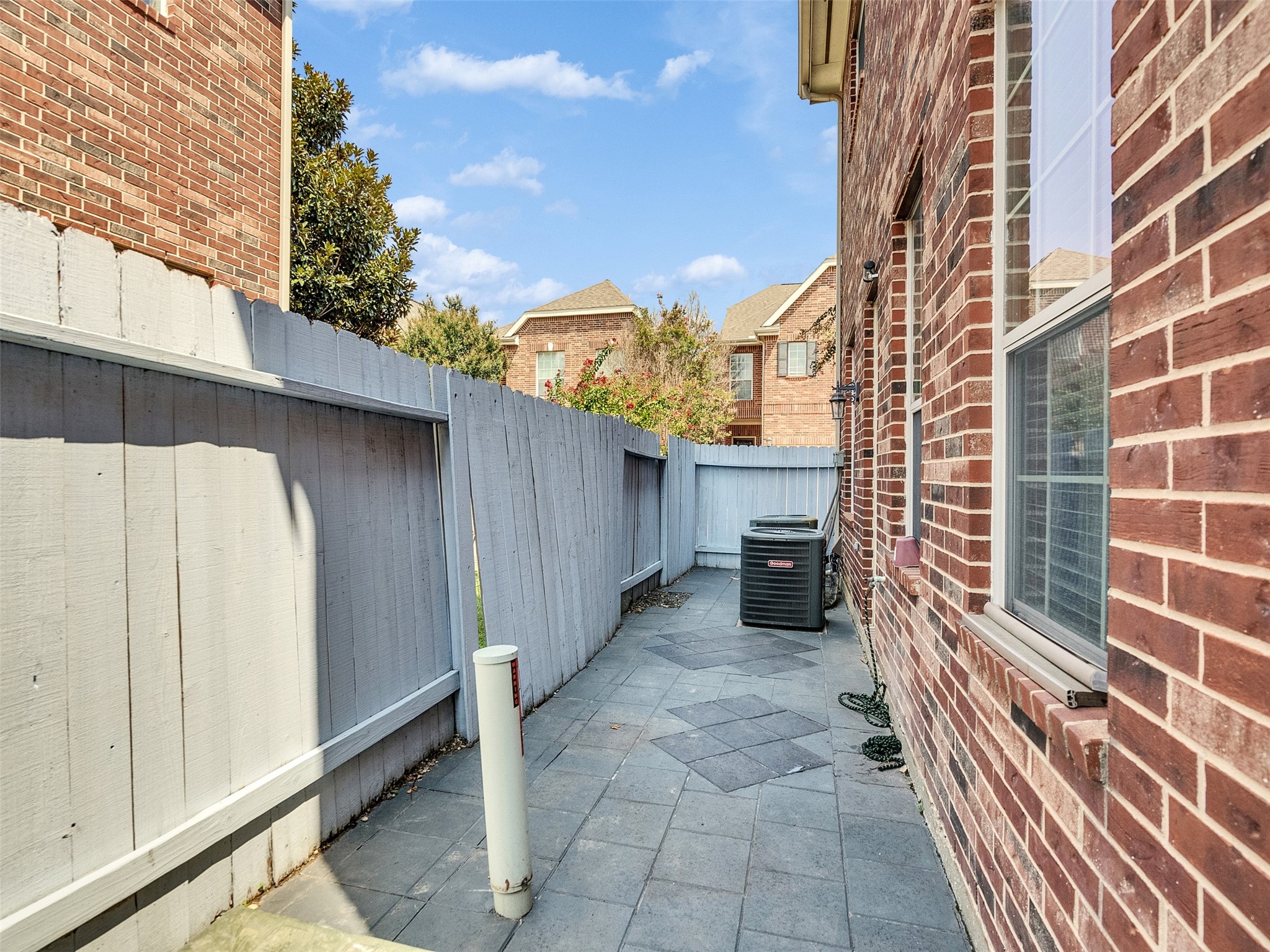 1502 Olive Place Houston, TX 77077 - Photo 23 of 27 Private patio with stone tiled flooring, bordered by a white fence and brick exterior - perfect for outdoor relaxation or entertaining