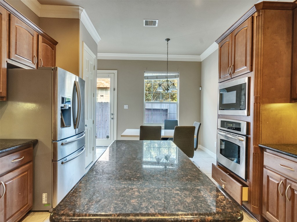 1502 Olive Place Houston, TX 77077 - Photo 9 of 27 Spacious kitchen with granite island, stainless steel refrigerator, and breakfast table—both available to buyer