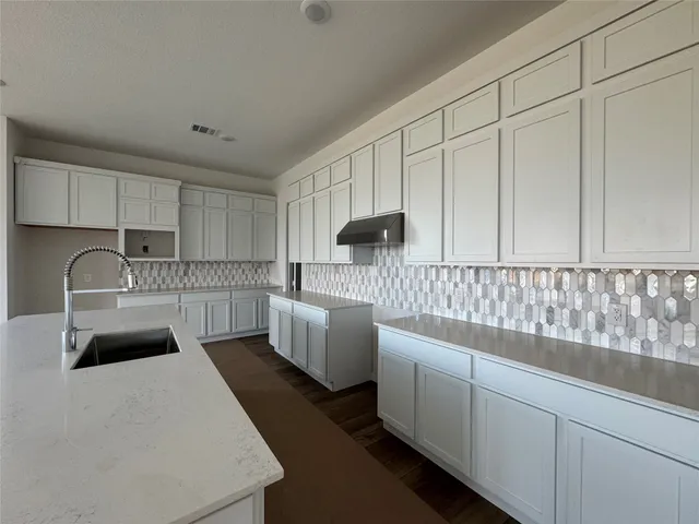 a kitchen with stainless steel appliances a sink a stove a refrigerator and cabinets