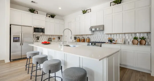 a kitchen with kitchen island white cabinets and refrigerator