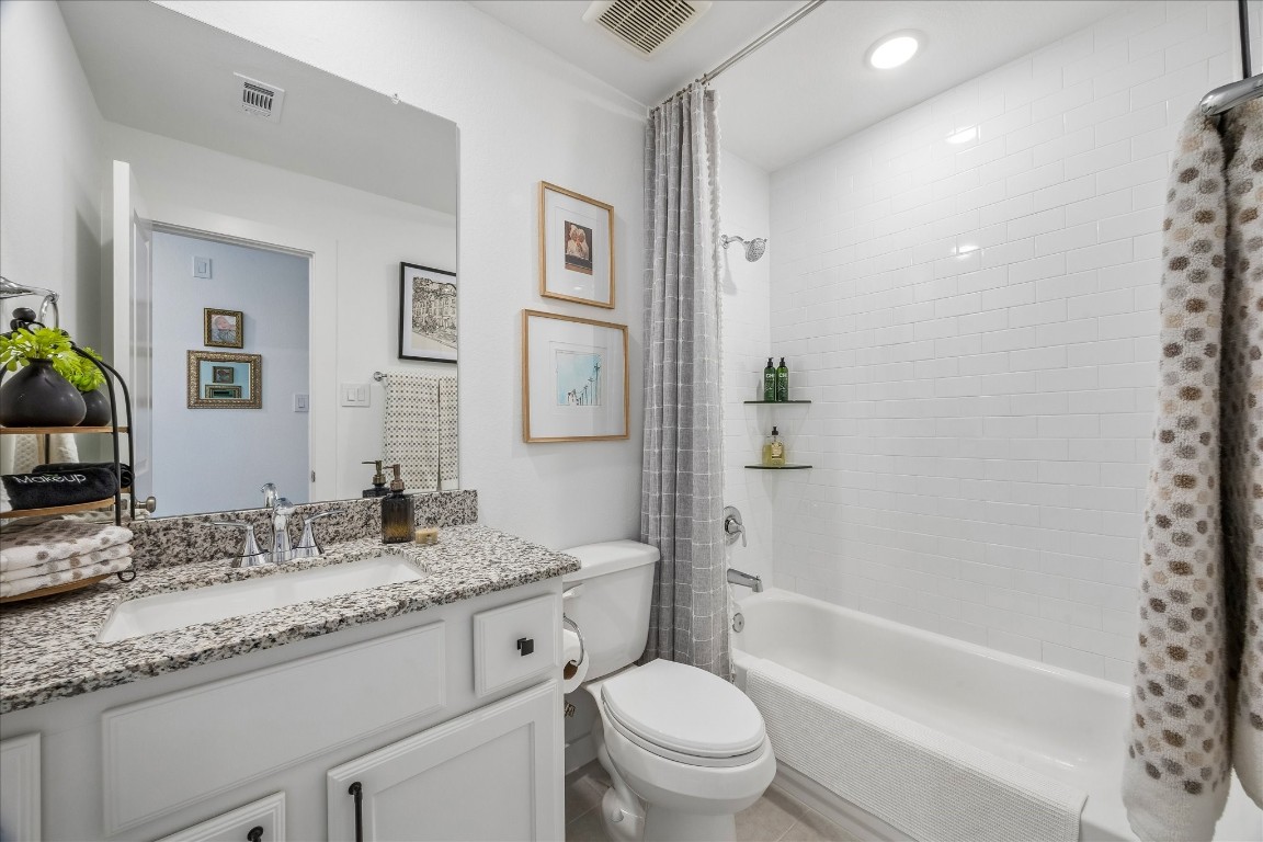 438 Livermore Street Webster, TX 77598 - Photo 25 of 34 a bathroom with a granite countertop toilet a sink and a bathtub